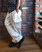 Person leaning against a brick wall indoors with a plant in the corner.