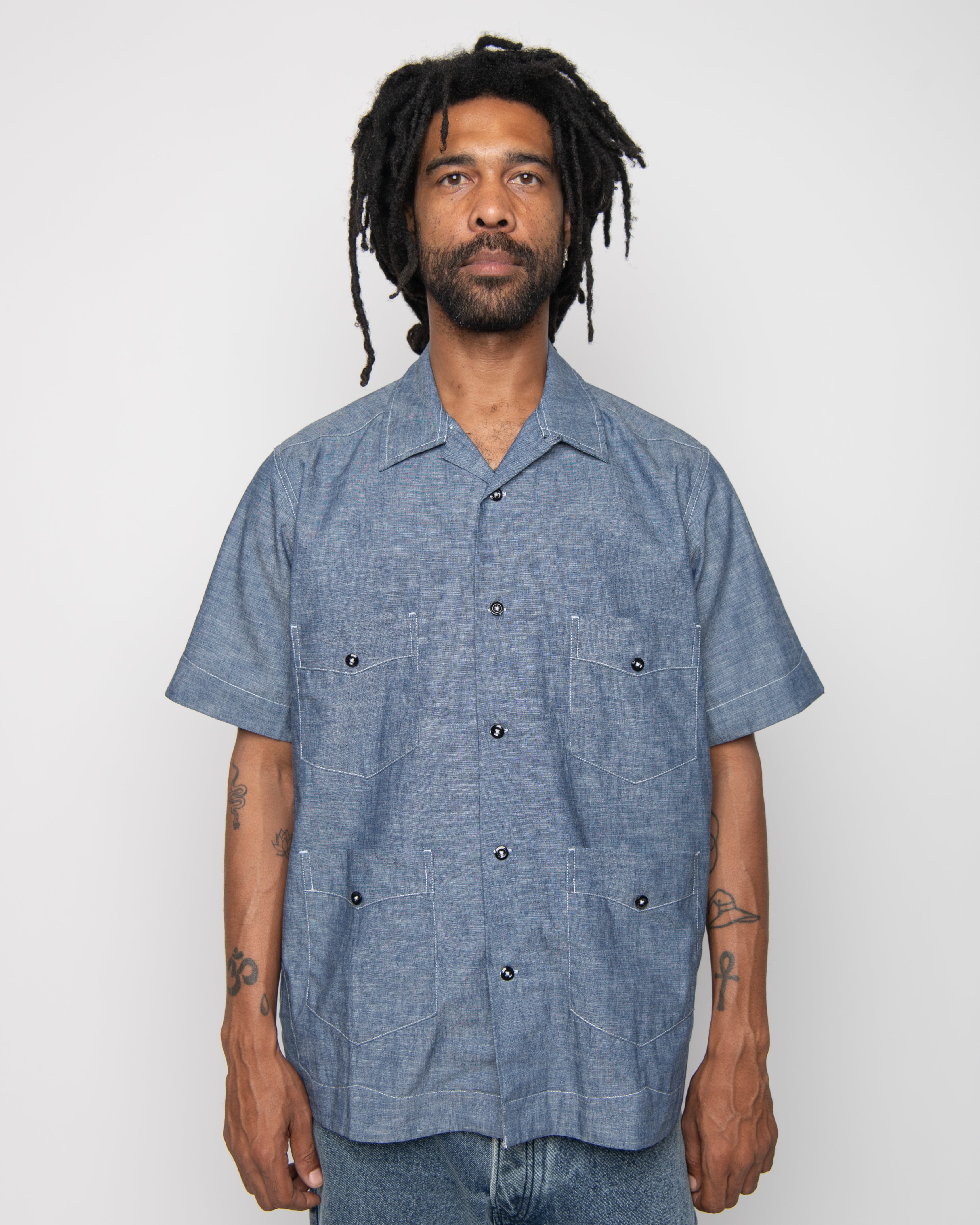Man wearing a blue short-sleeve shirt against a white background
